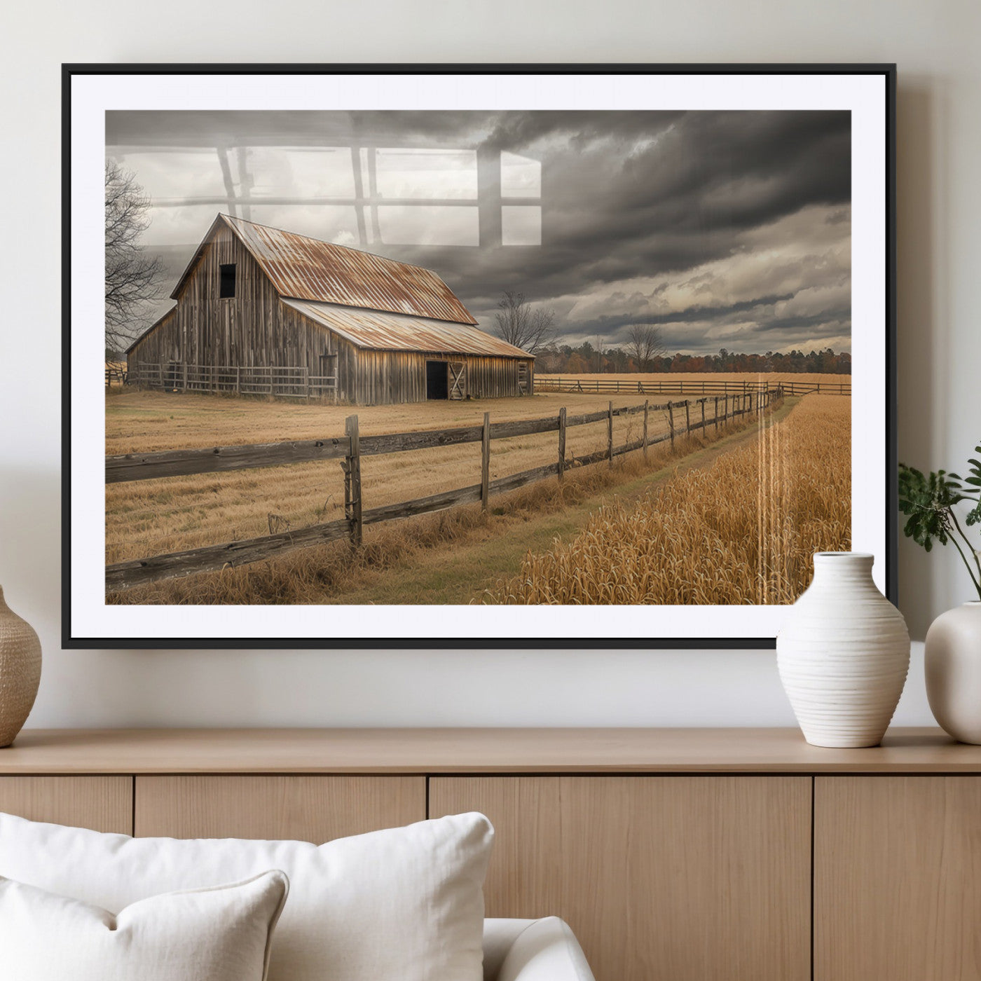 "Rustic barn with a weathered metal roof, surrounded by a wooden fence and golden fields under an overcast sky with dramatic clouds."