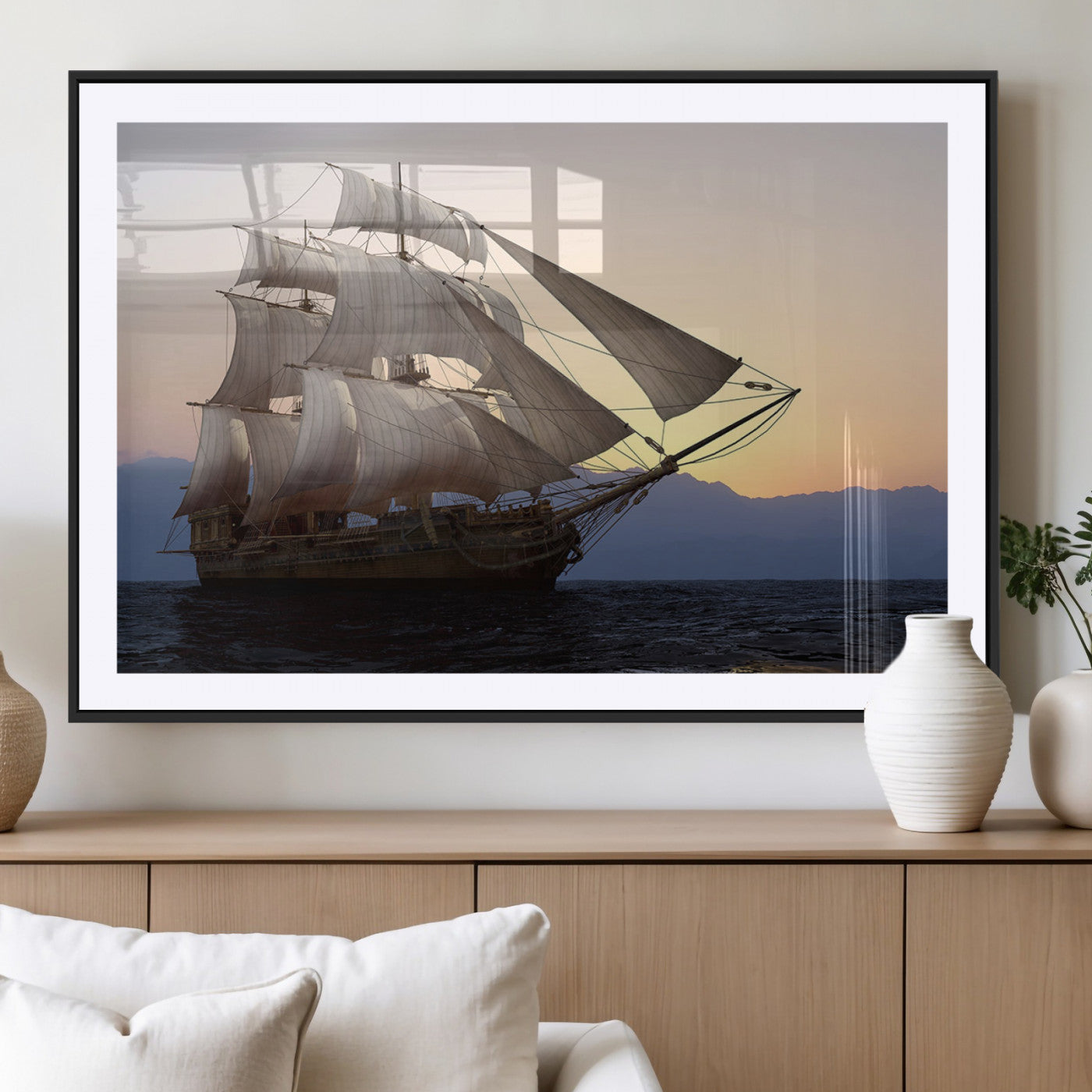 Majestic tall ship with full sails gliding across the ocean at sunset, with mountain silhouettes in the background – Wall Art Canvas Print.