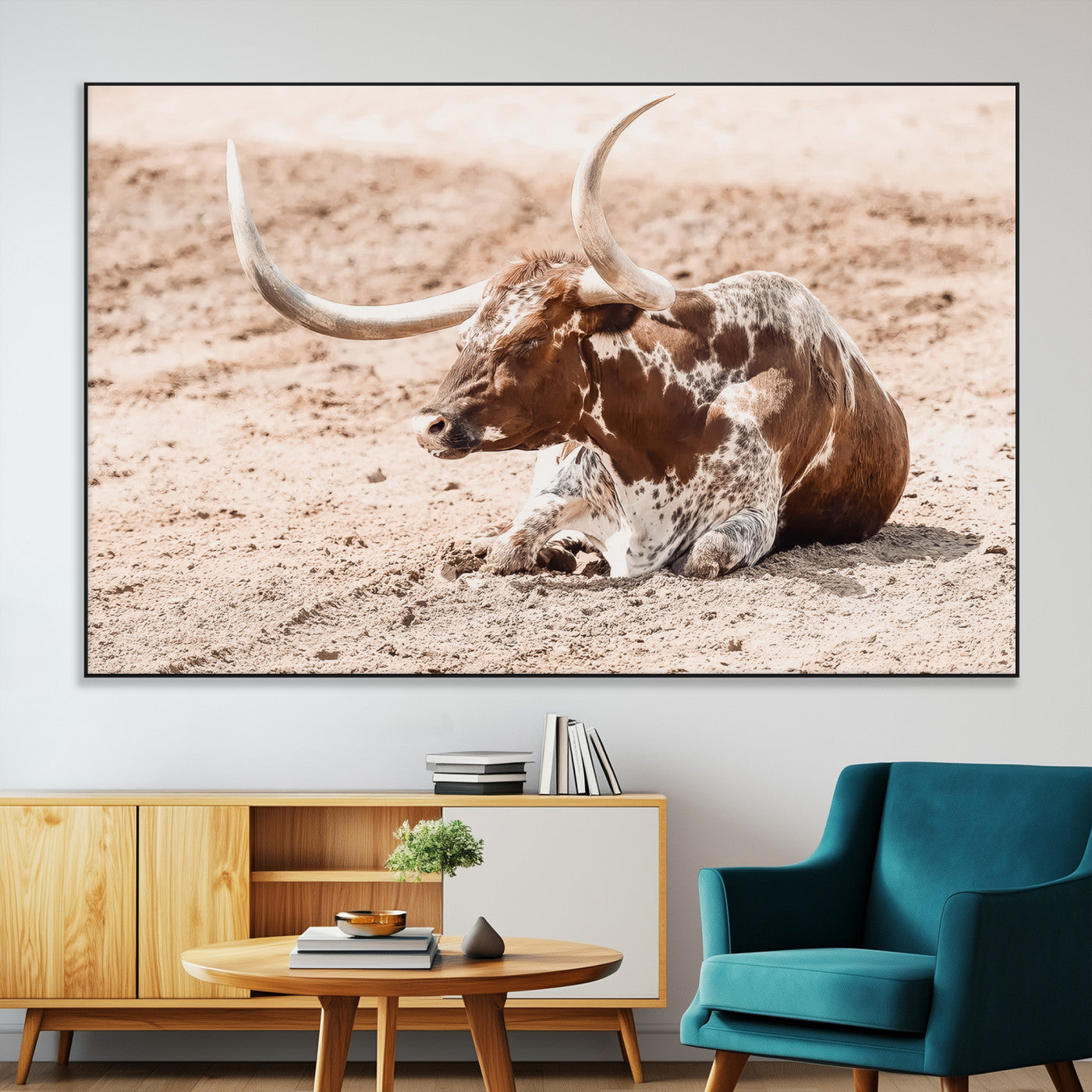 Texas Longhorn bull resting on dusty ground with warm tones, ideal for rustic western or farmhouse-themed wall decor.