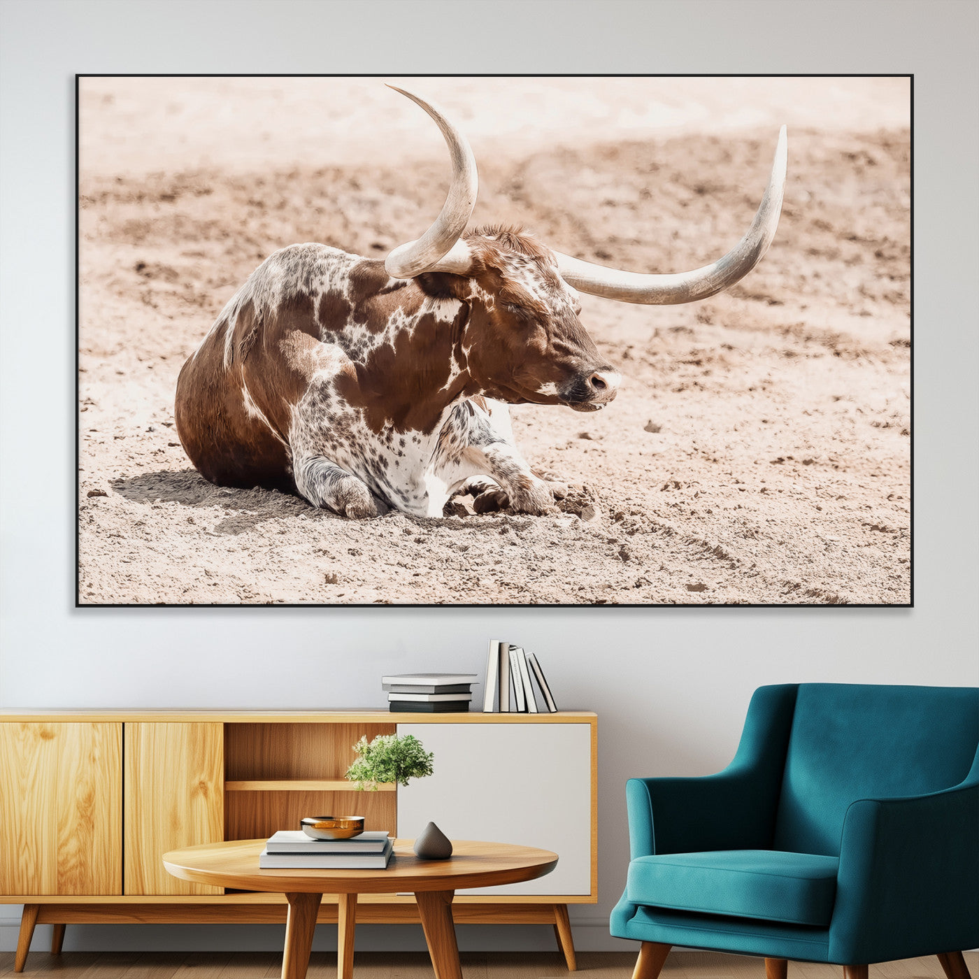 Texas Longhorn bull resting on dusty ground with warm tones, ideal for rustic western or farmhouse-themed wall decor.