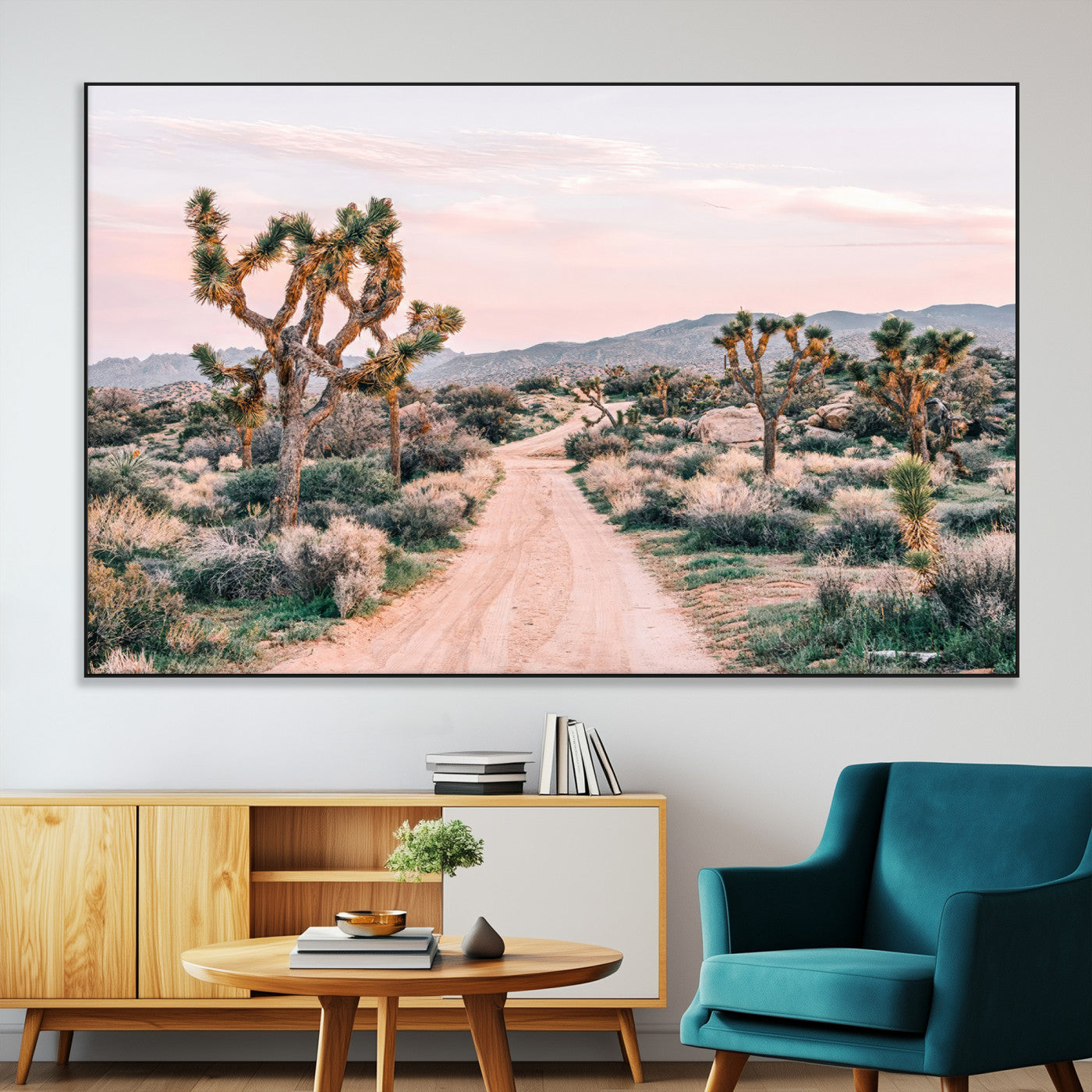 A dusty road winding through Joshua Tree National Park, framed by iconic twisted trees and warm desert tones under a soft pastel sky.