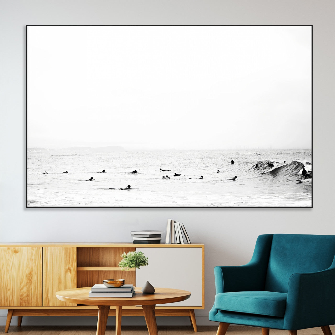 A group of surfers floating in the ocean, waiting for waves under a vast, moody sky, captured in black and white.