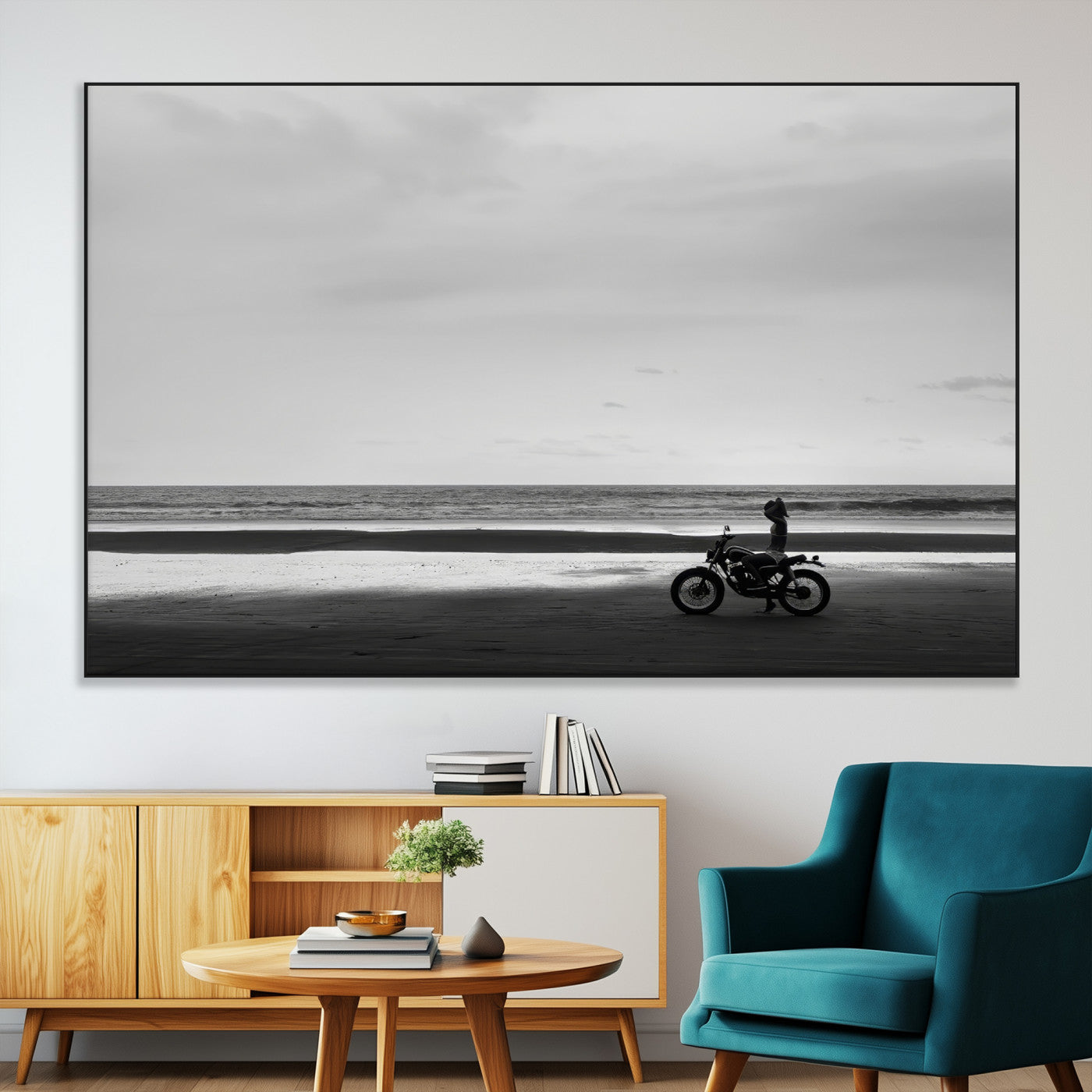 A motorcyclist on a vast beach, gazing at the ocean, capturing a moody and tranquil coastal adventure in black and white.