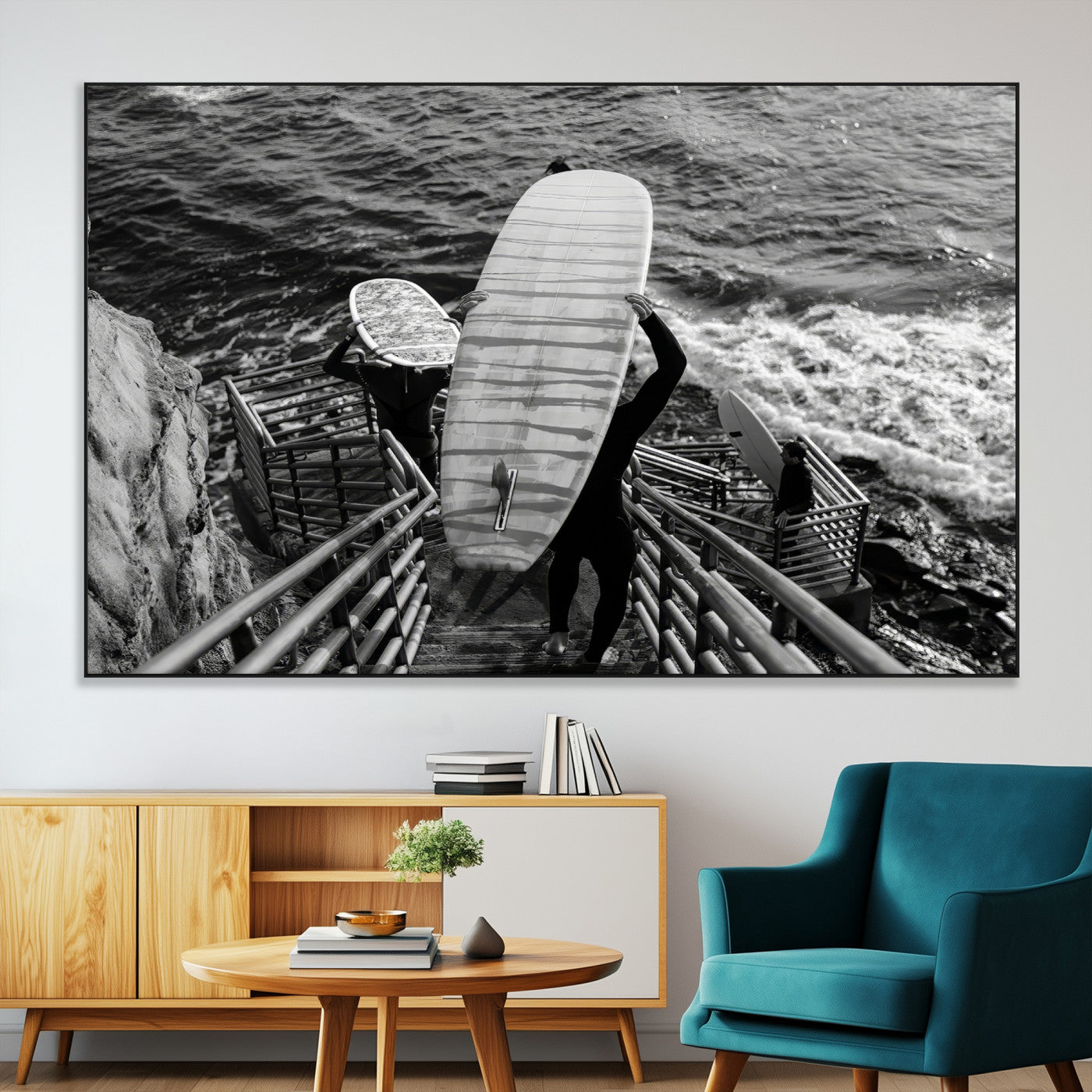 Black and white photo of surfers carrying boards down a rugged cliffside stairway, capturing a bold and adventurous coastal scene.