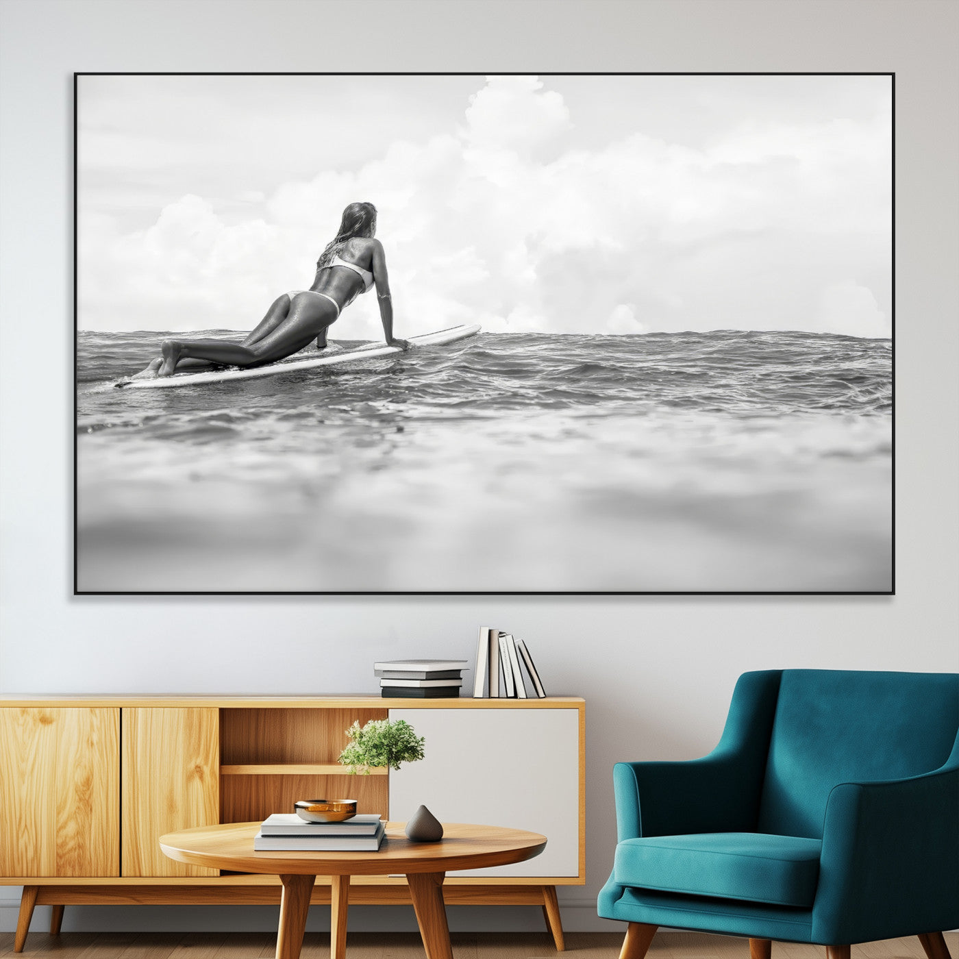 A black and white ocean scene featuring a surfer girl waiting on her board, gazing at the horizon, capturing a tranquil and adventurous coastal moment.