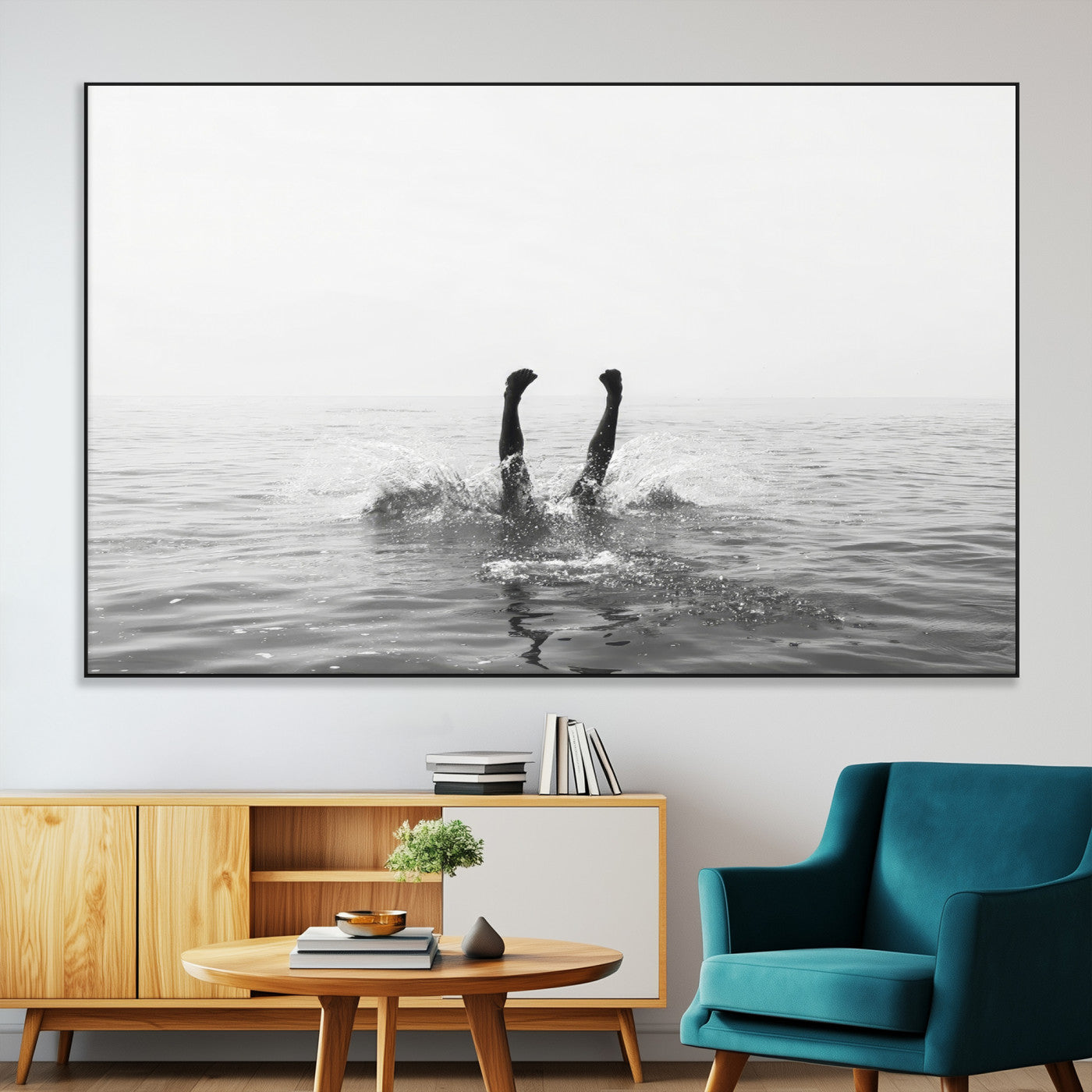 A black and white minimalist water scene capturing a playful splash as a swimmer dives upside down, creating a carefree and artistic aquatic aesthetic.