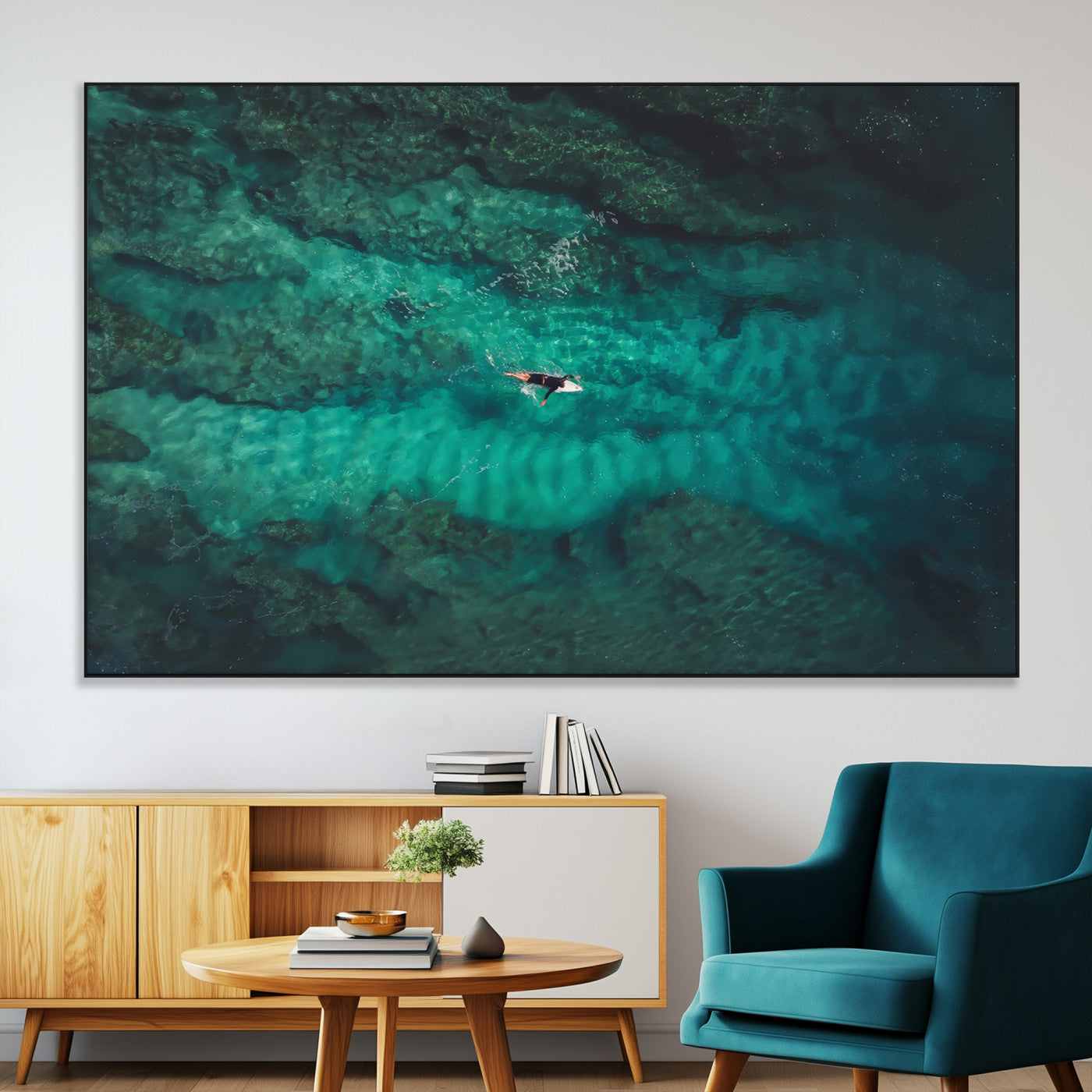 An aerial view of a solo surfer paddling through crystal-clear turquoise waters over a sunlit reef, capturing the beauty and serenity of open water surfing.