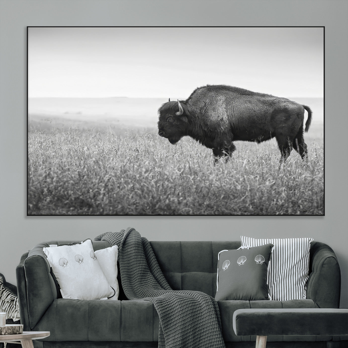 A black and white photograph of a majestic bison standing in a vast grassy prairie, evoking a sense of wilderness and strength.