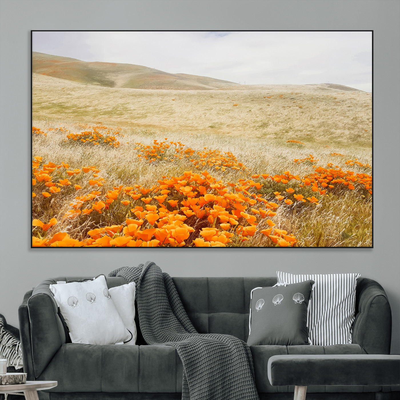 A golden field with vibrant orange poppies blooming across rolling hills under a soft, sunlit sky, creating a warm and rustic landscape.