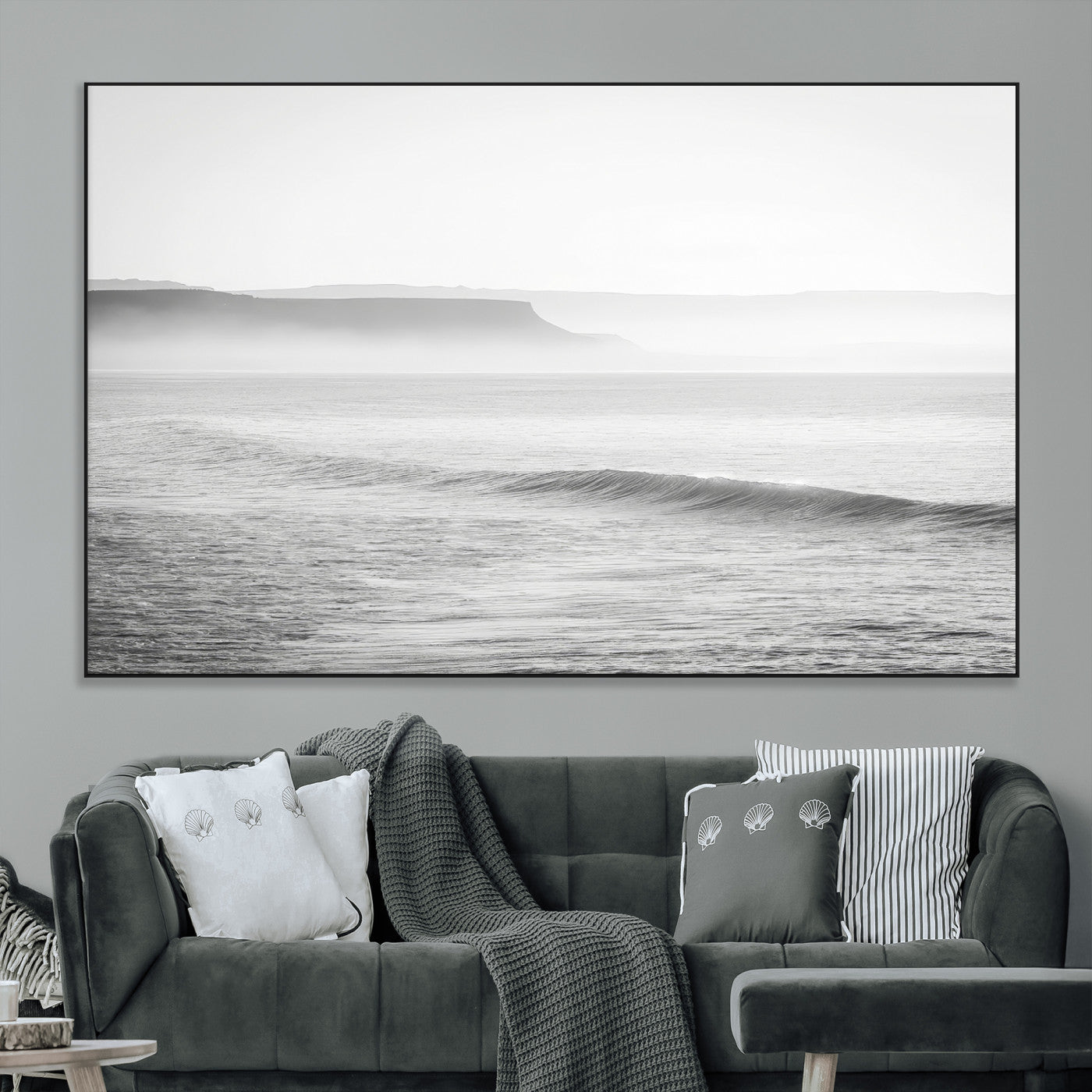 A black and white minimalist seascape featuring soft rolling waves and misty distant cliffs, creating a serene and timeless coastal atmosphere.