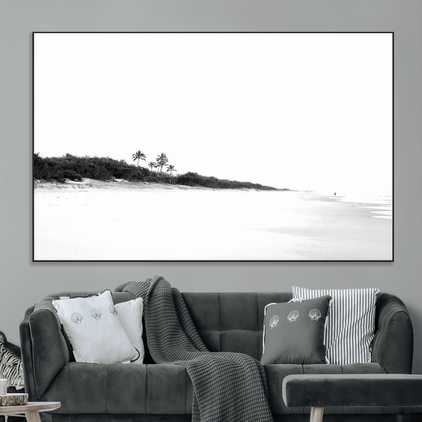 A black and white minimalist coastal scene with a vast open beach, distant palm trees, and a lone figure walking along the shoreline, evoking serenity and solitude.