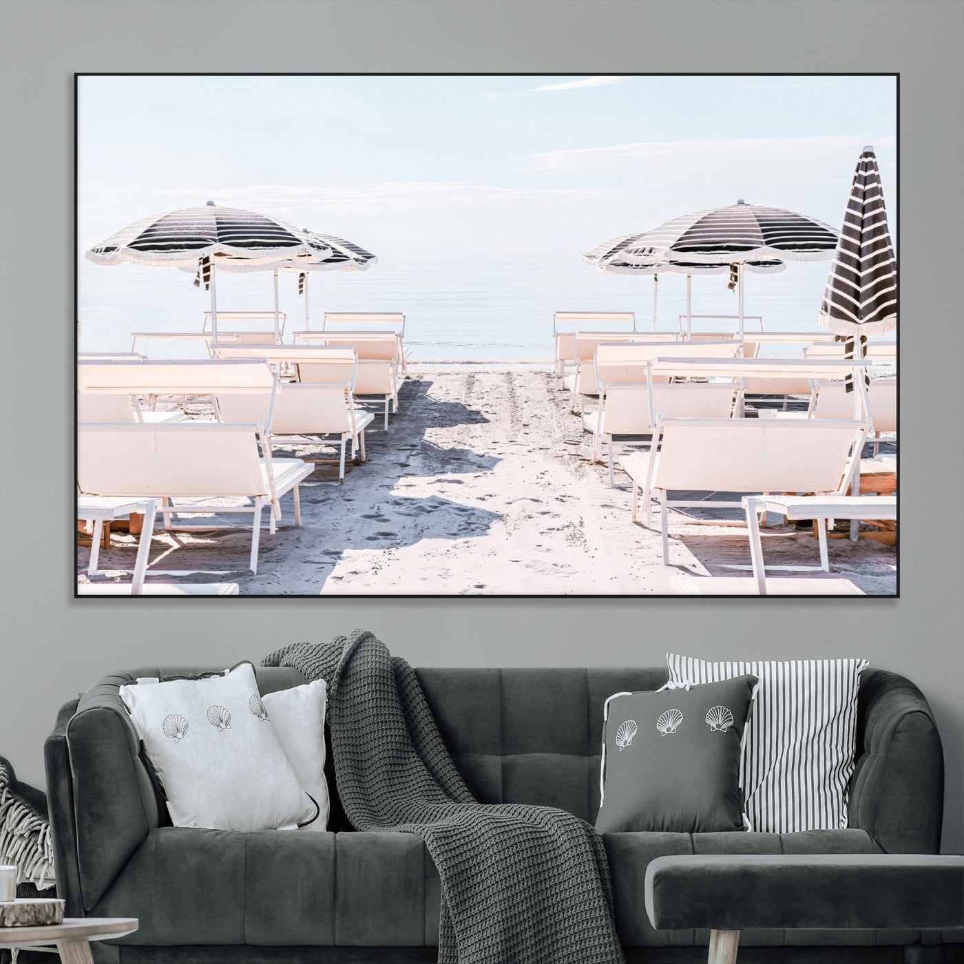 A serene minimalist beach scene featuring striped umbrellas, soft pastel sand, and an elegant lounge setup, creating a tranquil and stylish coastal retreat.
