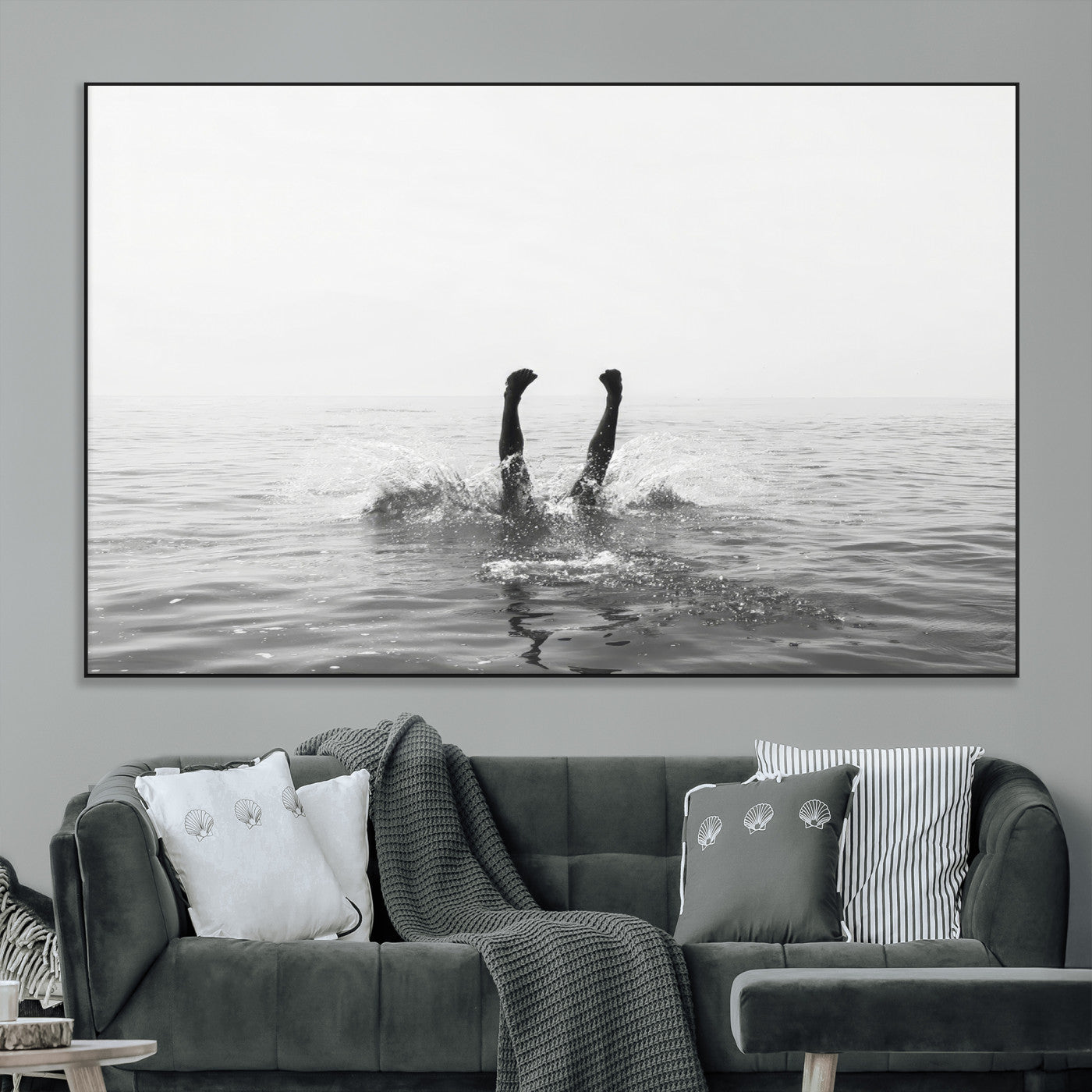 A black and white minimalist water scene capturing a playful splash as a swimmer dives upside down, creating a carefree and artistic aquatic aesthetic.