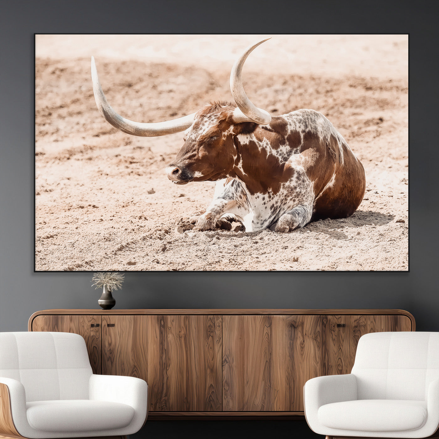 Texas Longhorn bull resting on dusty ground with warm tones, ideal for rustic western or farmhouse-themed wall decor.