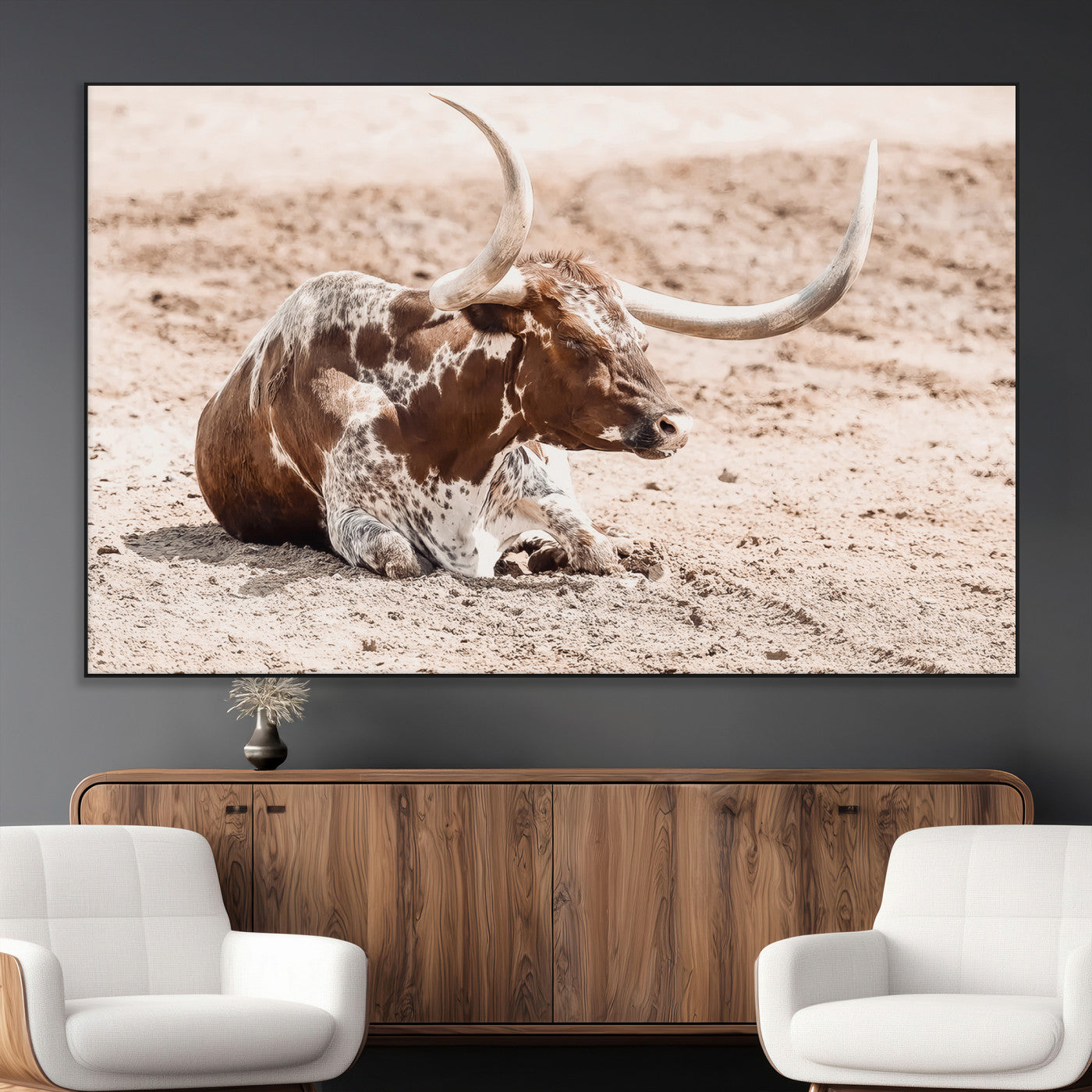 Texas Longhorn bull resting on dusty ground with warm tones, ideal for rustic western or farmhouse-themed wall decor.