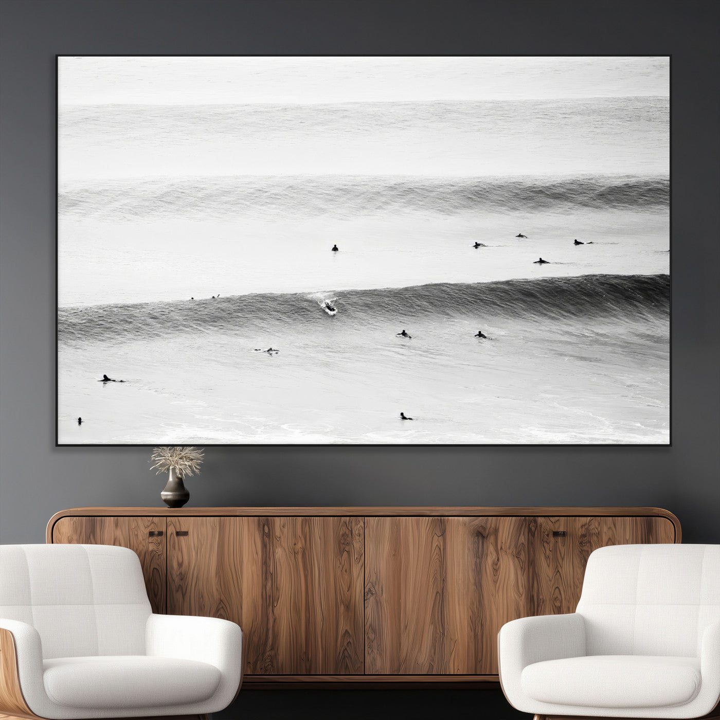 A monochrome photograph of swimmers gliding through gentle ocean waves, evoking a sense of calm and movement.