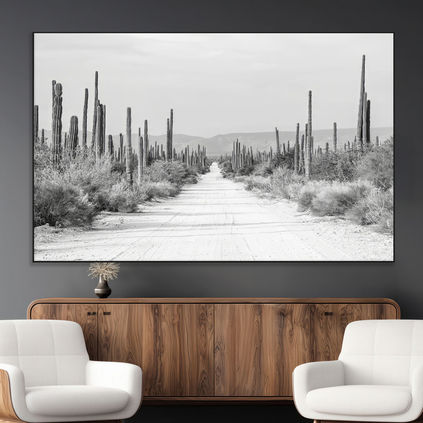 A black and white desert road stretching through a cactus-filled landscape, creating a rugged and timeless southwestern aesthetic with a sense of adventure.