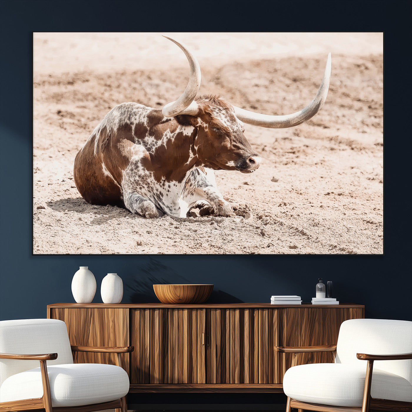 Texas Longhorn bull resting on dusty ground with warm tones, ideal for rustic western or farmhouse-themed wall decor.