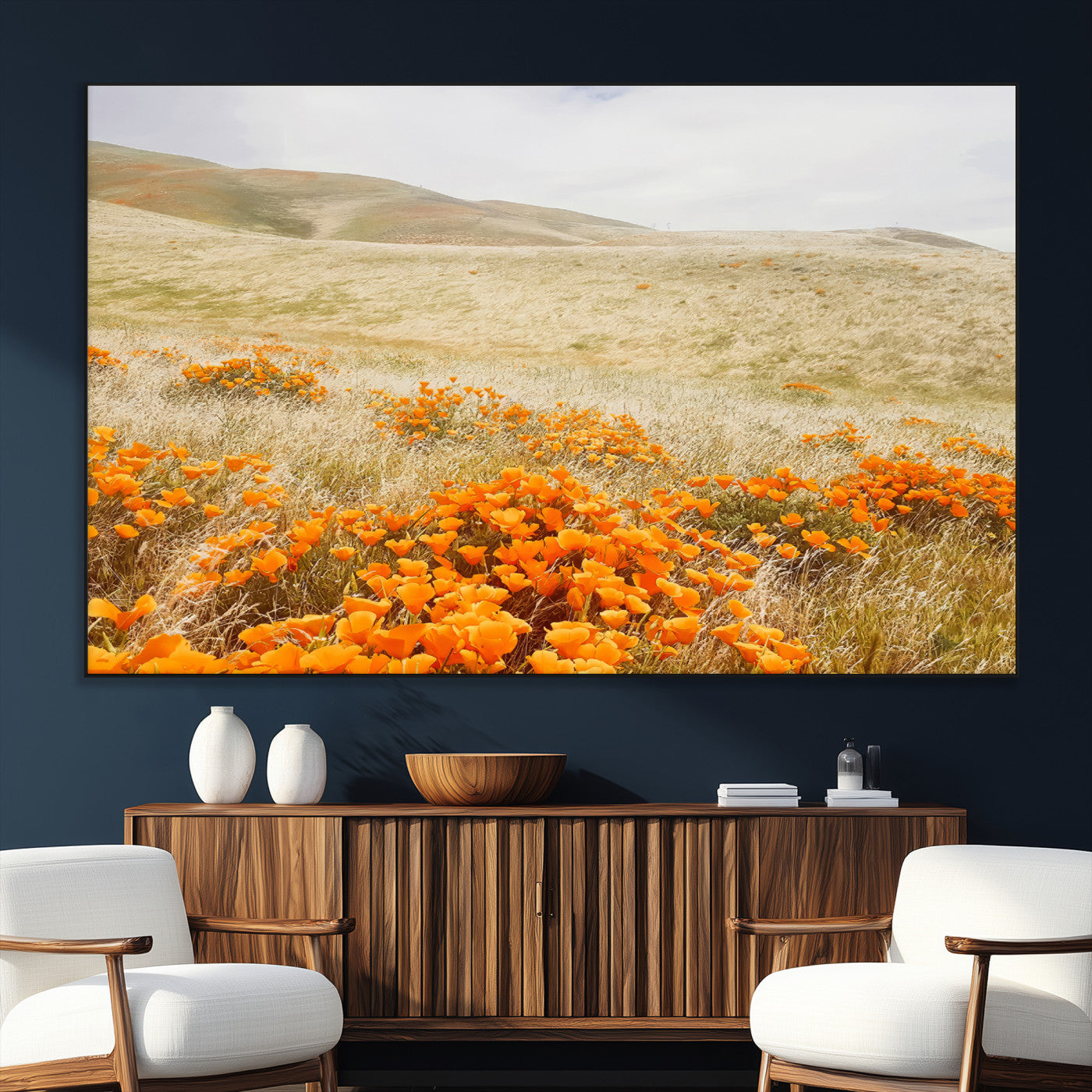 A golden field with vibrant orange poppies blooming across rolling hills under a soft, sunlit sky, creating a warm and rustic landscape.