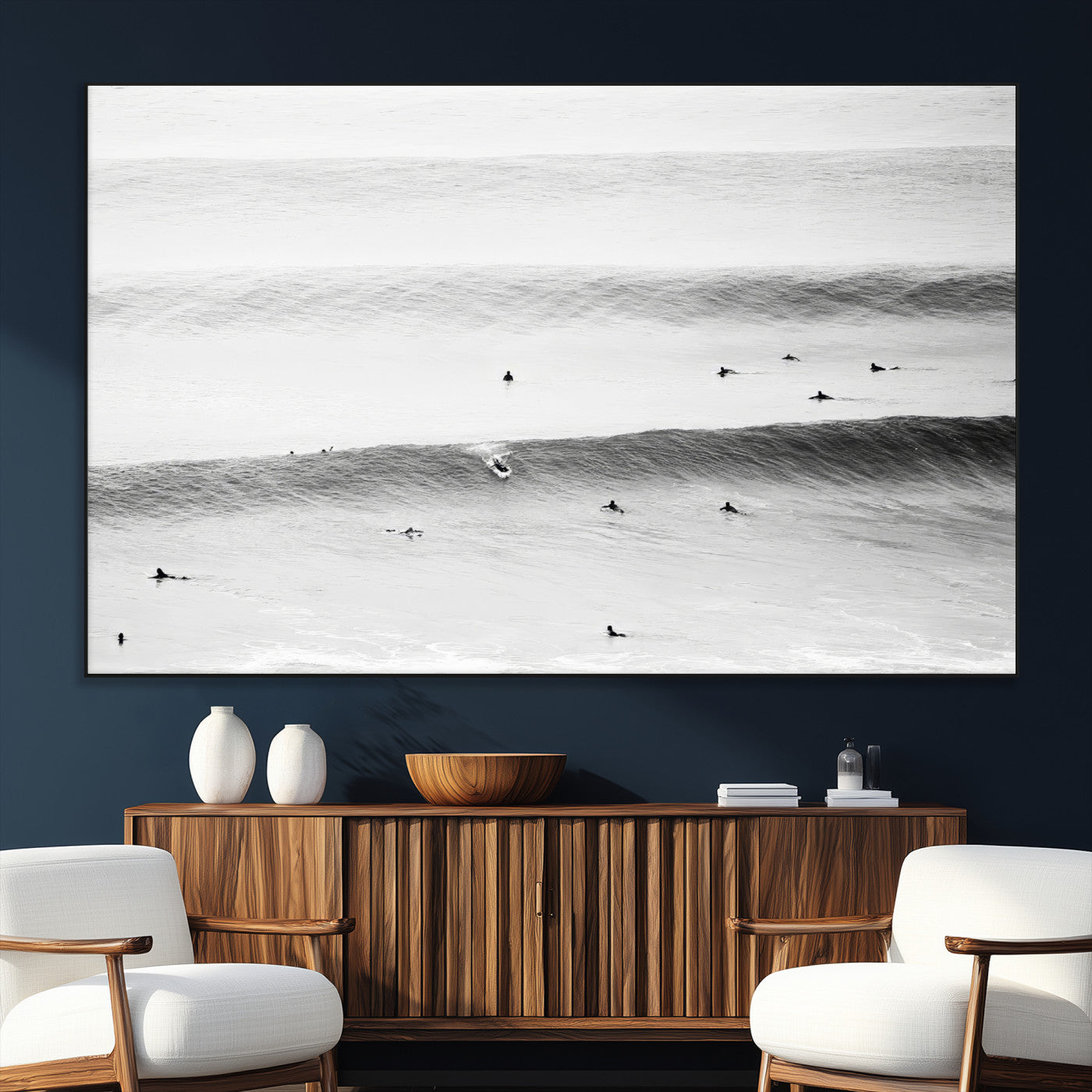 A monochrome photograph of swimmers gliding through gentle ocean waves, evoking a sense of calm and movement.
