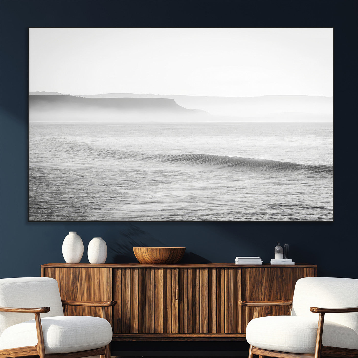 A black and white minimalist seascape featuring soft rolling waves and misty distant cliffs, creating a serene and timeless coastal atmosphere.