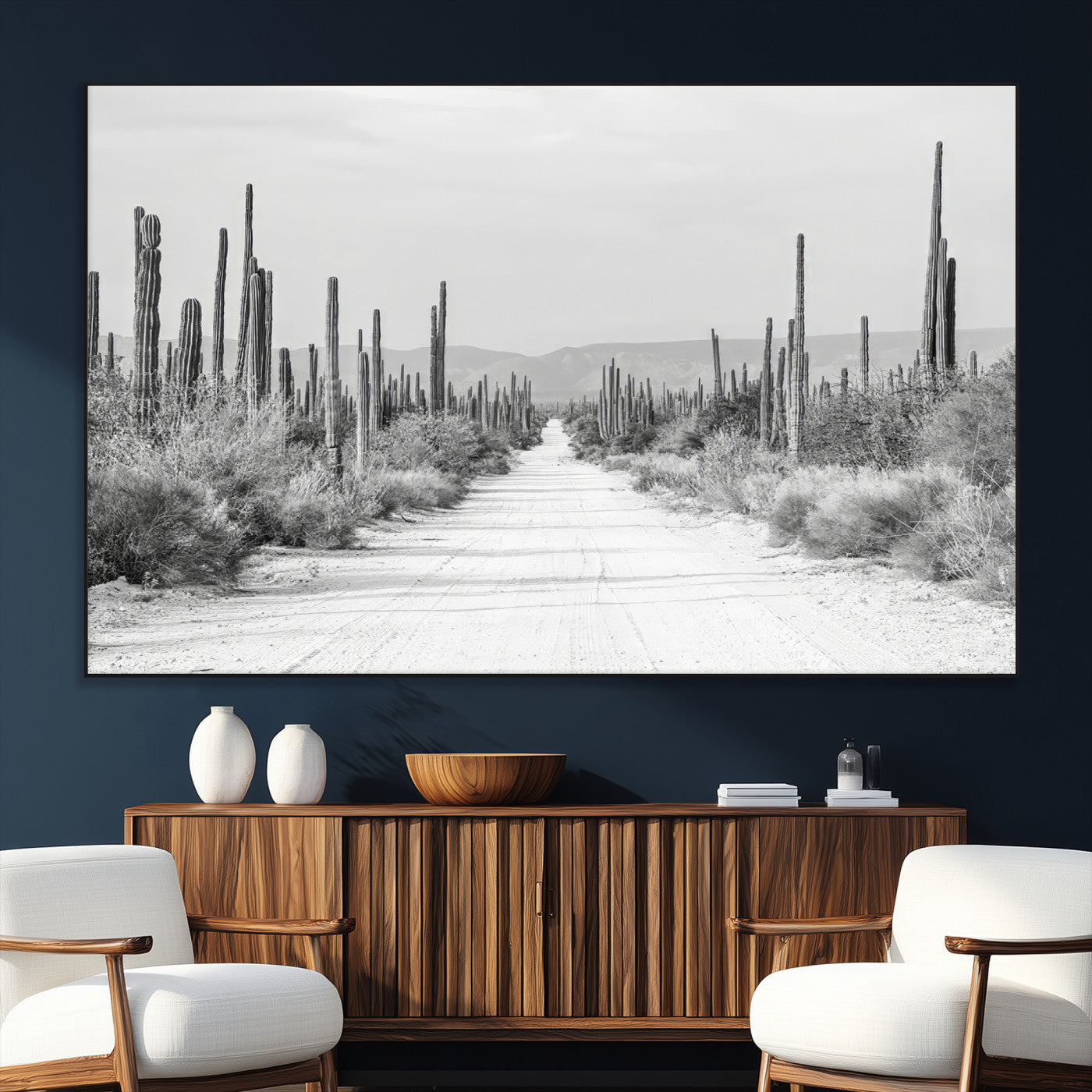 A black and white desert road stretching through a cactus-filled landscape, creating a rugged and timeless southwestern aesthetic with a sense of adventure.
