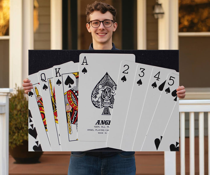 The Poker Wall Art - Playing Cards Canvas Wall Art Print features an Ace of Spades and Royal Flush design. This piece adds a classic charm to any space with its subtle emphasis on the Ace of Spades, making it perfect for game room decor.