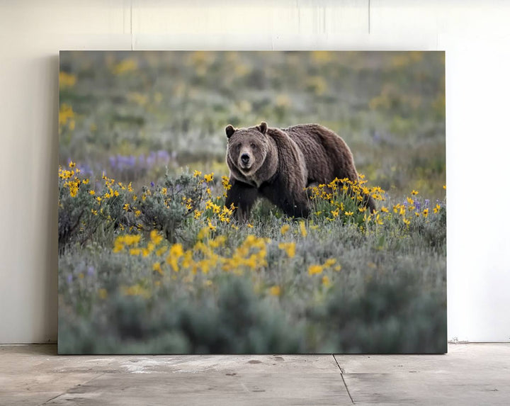 The "Queen of the Tetons" is a stunning canvas wall art print featuring Grizzly 399 walking through a field of yellow and purple flowers, showcasing the gallery-quality finish.