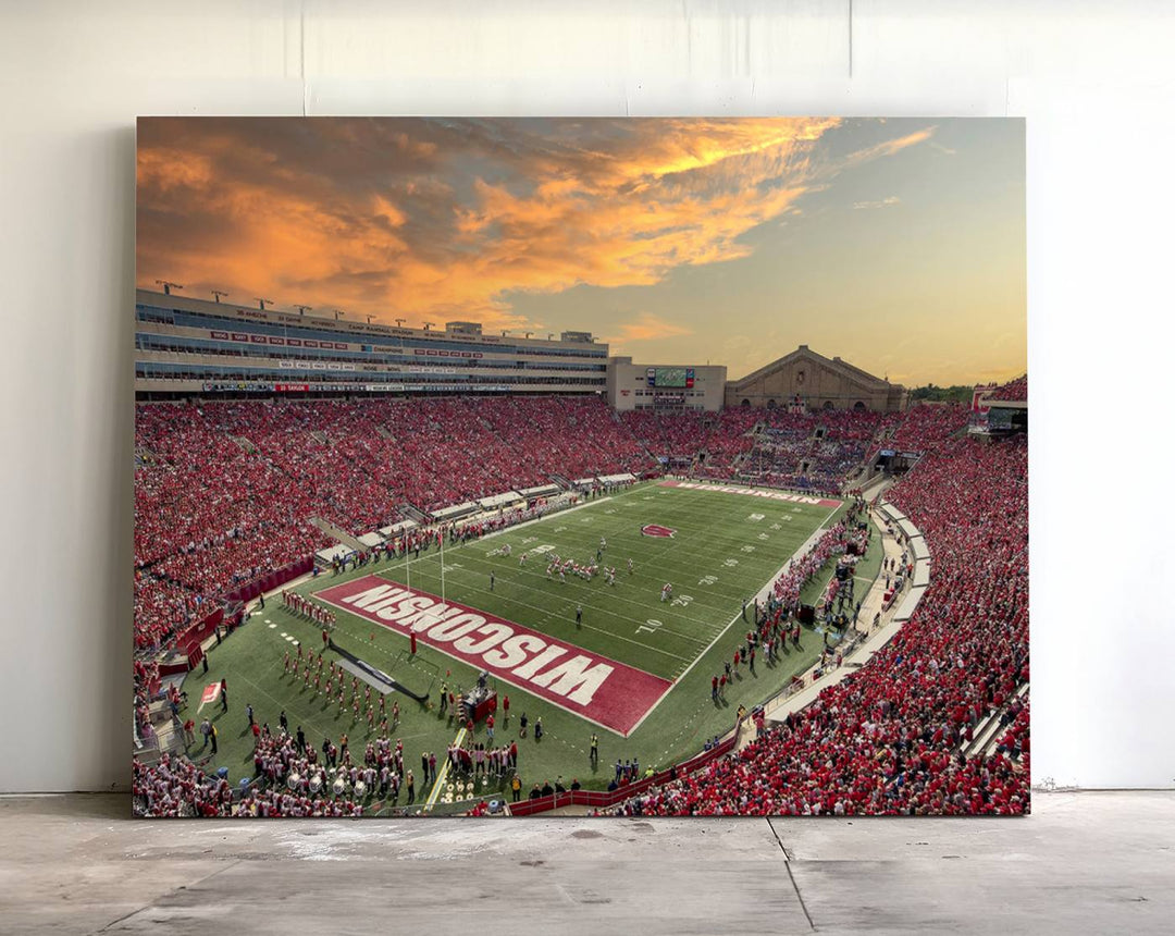 The wall features a Wisconsin Badgers wall art canvas print, capturing the vibrant atmosphere of a full Camp Randall Stadium at sunset.