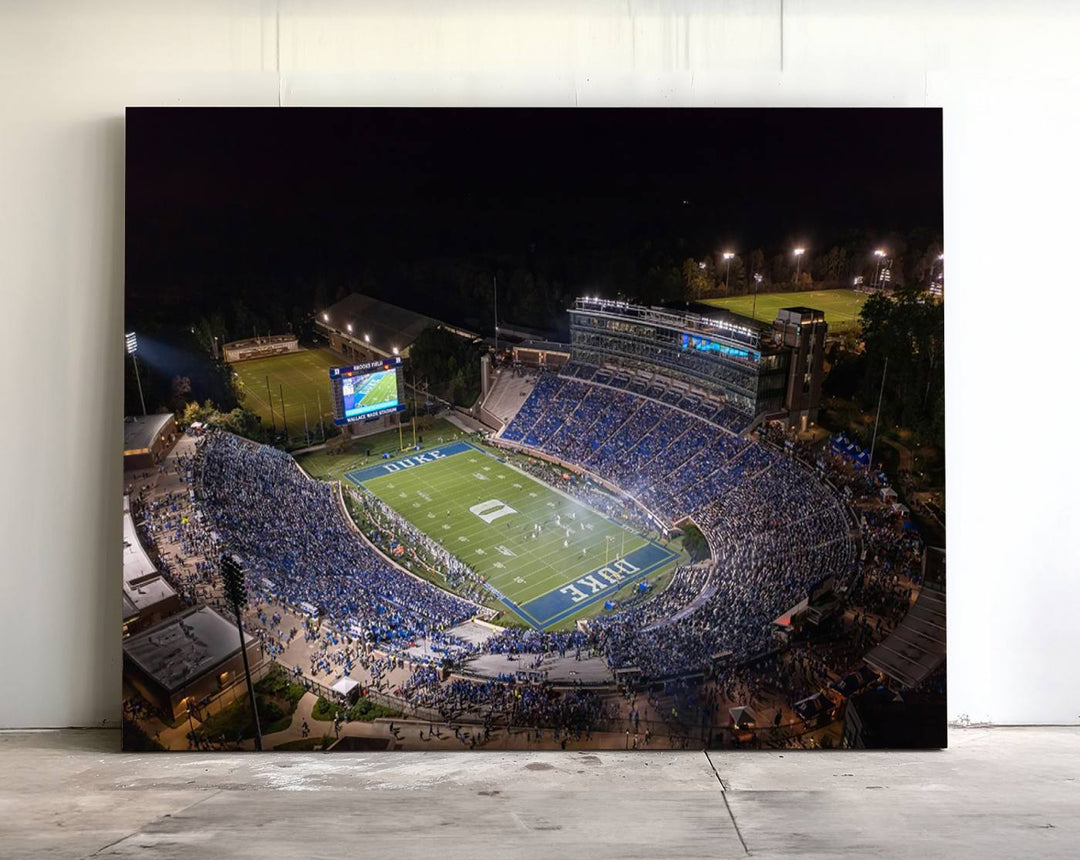 Night aerial view of packed Duke Blue Devils Wallace Wade Stadium, surrounded by trees and illuminated by lights; perfect for high-resolution prints.