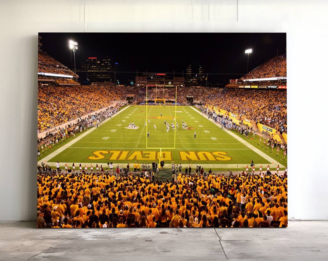 The Phoenix Stadium Canvas Wall Art features a vibrant depiction of a packed stadium filled with ASU Sun Devils fans wearing yellow shirts.