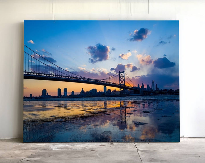 A photograph titled "Large Wall Art Philadelphia Canvas Print - Benjamin Franklin Bridge at Sunset" displays a breathtaking cityscape of the bridge reflected in the water. This image features a gallery-quality finish that promises to transform any space into an evocative memory.