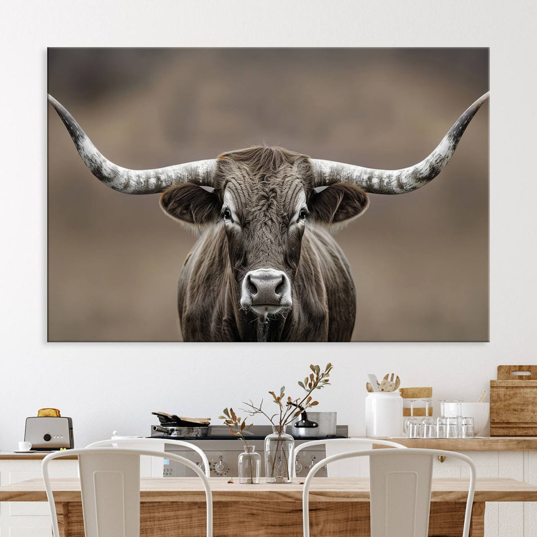 A close-up of a longhorn bull facing forward is featured in the Framed Texas Test-1, set against a blurred brown background.