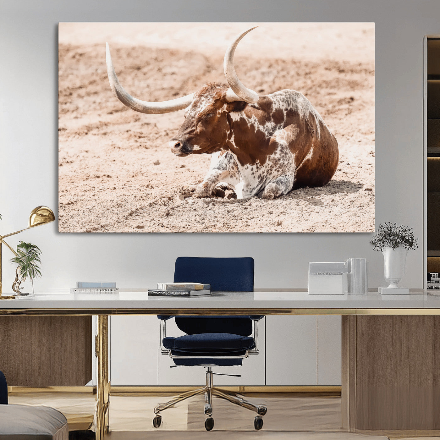 Texas Longhorn bull resting on dusty ground with warm tones, ideal for rustic western or farmhouse-themed wall decor.