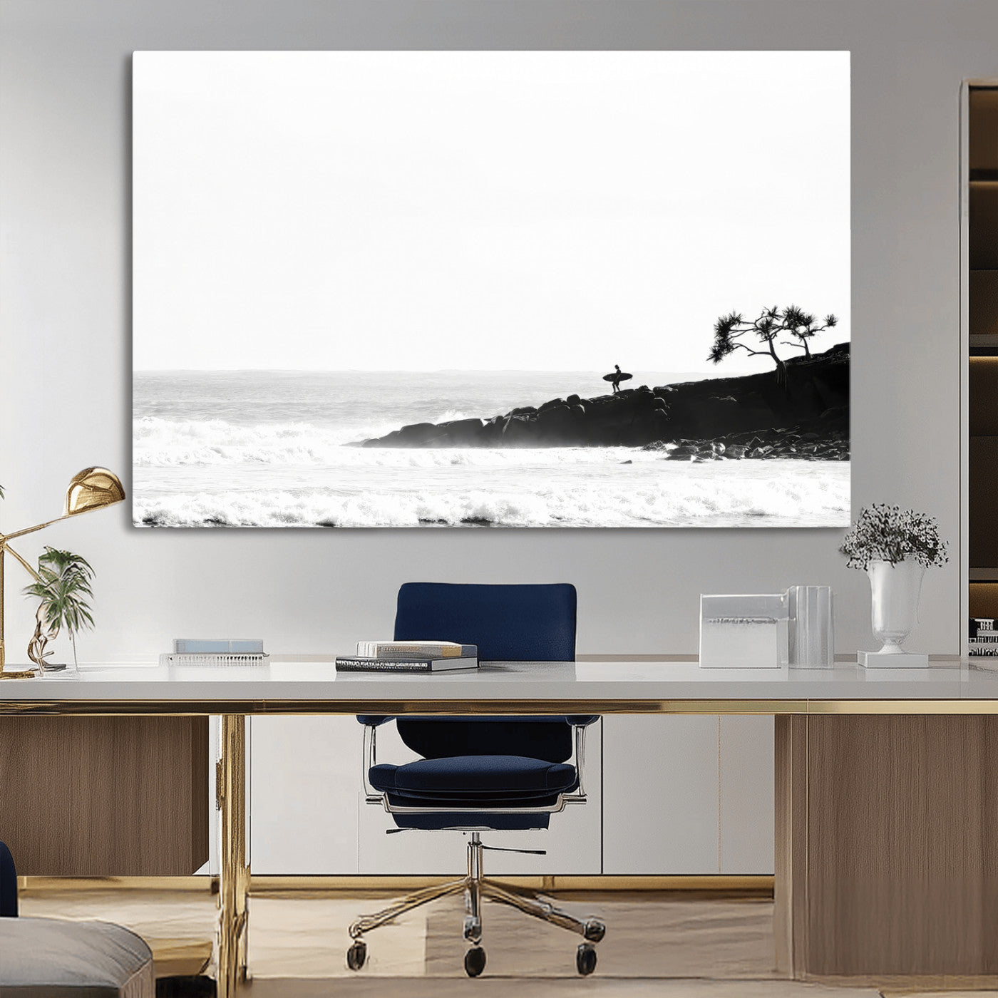 Black and white photo of a surfer standing on rocky cliffs, gazing at the waves, embodying the spirit of adventure and solitude.
