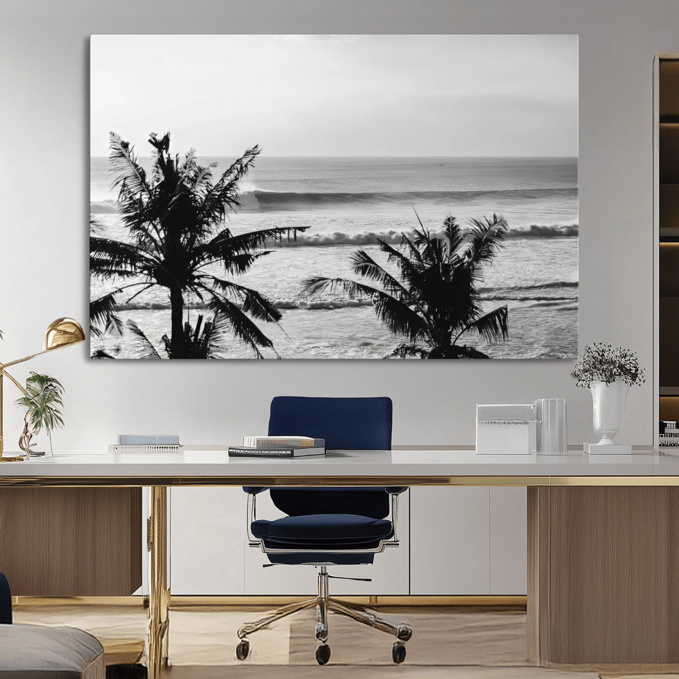 Black and white view of ocean waves crashing on a tropical coastline, framed by silhouetted palm trees under a vast, open sky.