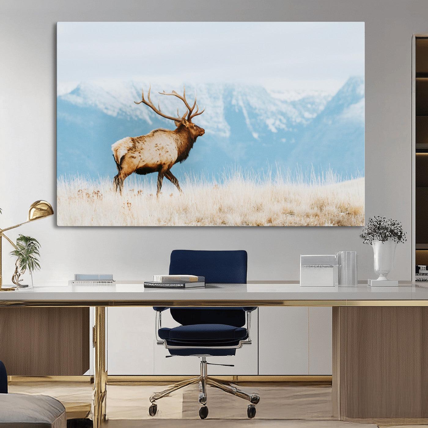 Majestic elk with antlers walking on golden grass, snowy mountains behind, perfect for rustic lodge or Scandinavian decor.
