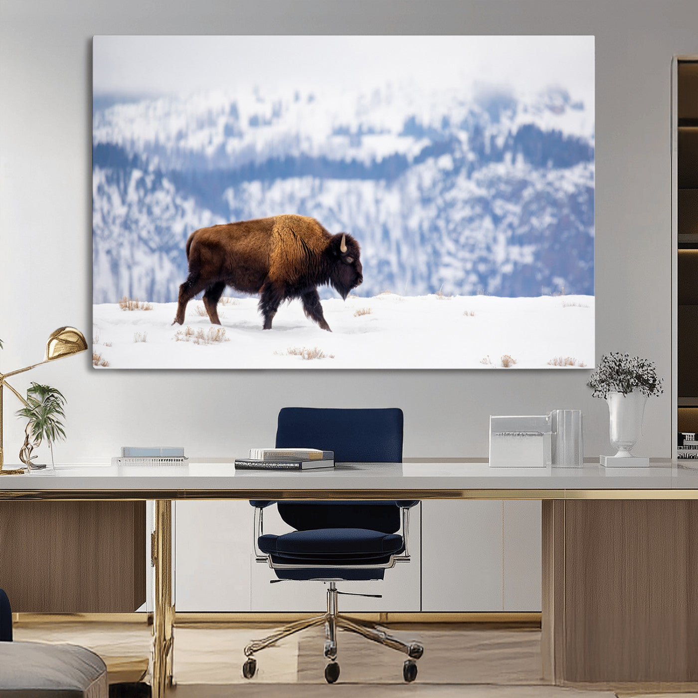 A lone bison walks across snowy ground with blue-toned mountain range behind, ideal for rustic or western farmhouse interiors.