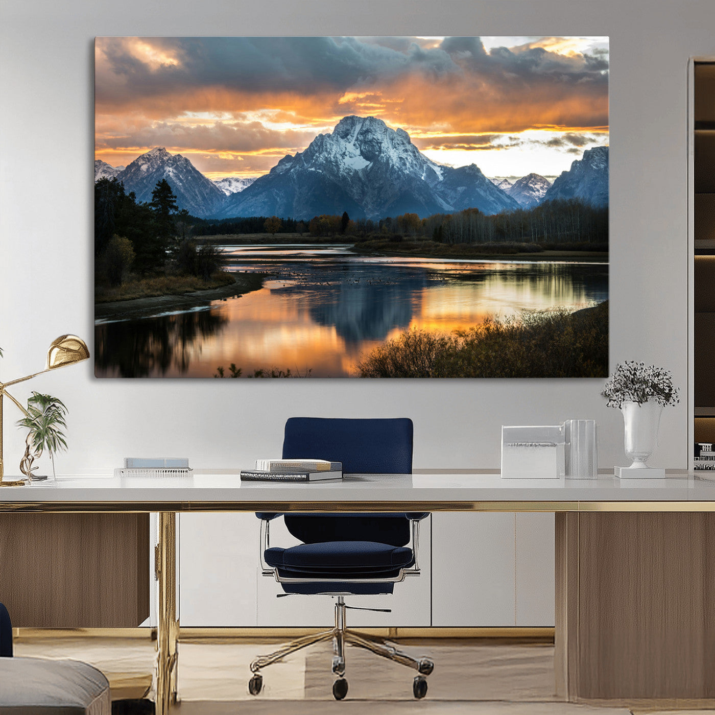 Snow-capped mountains reflecting in a calm lake at sunset, with a dramatic golden sky creating a breathtaking wilderness scene.