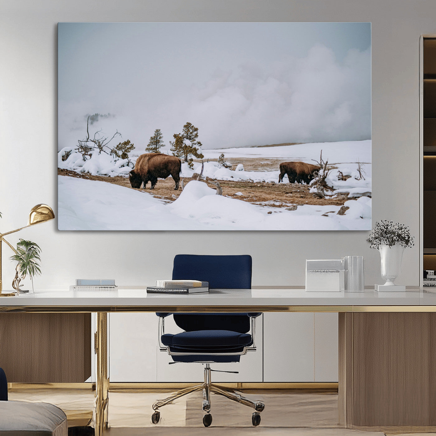 Two bison grazing in a snowy open landscape with misty hills in the background, creating a peaceful and rustic winter scene.
