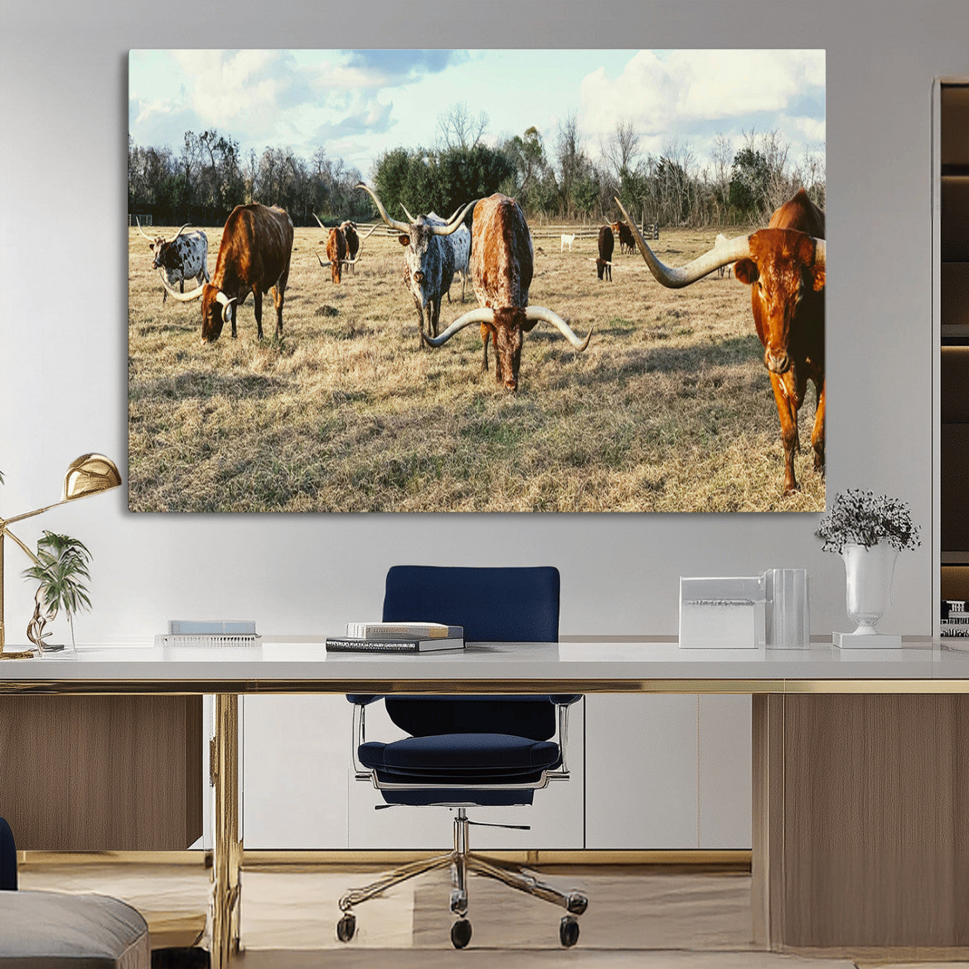 A herd of Texas Longhorn cattle grazing in an open field under a partly cloudy sky, capturing a rustic and Western ranch aesthetic.