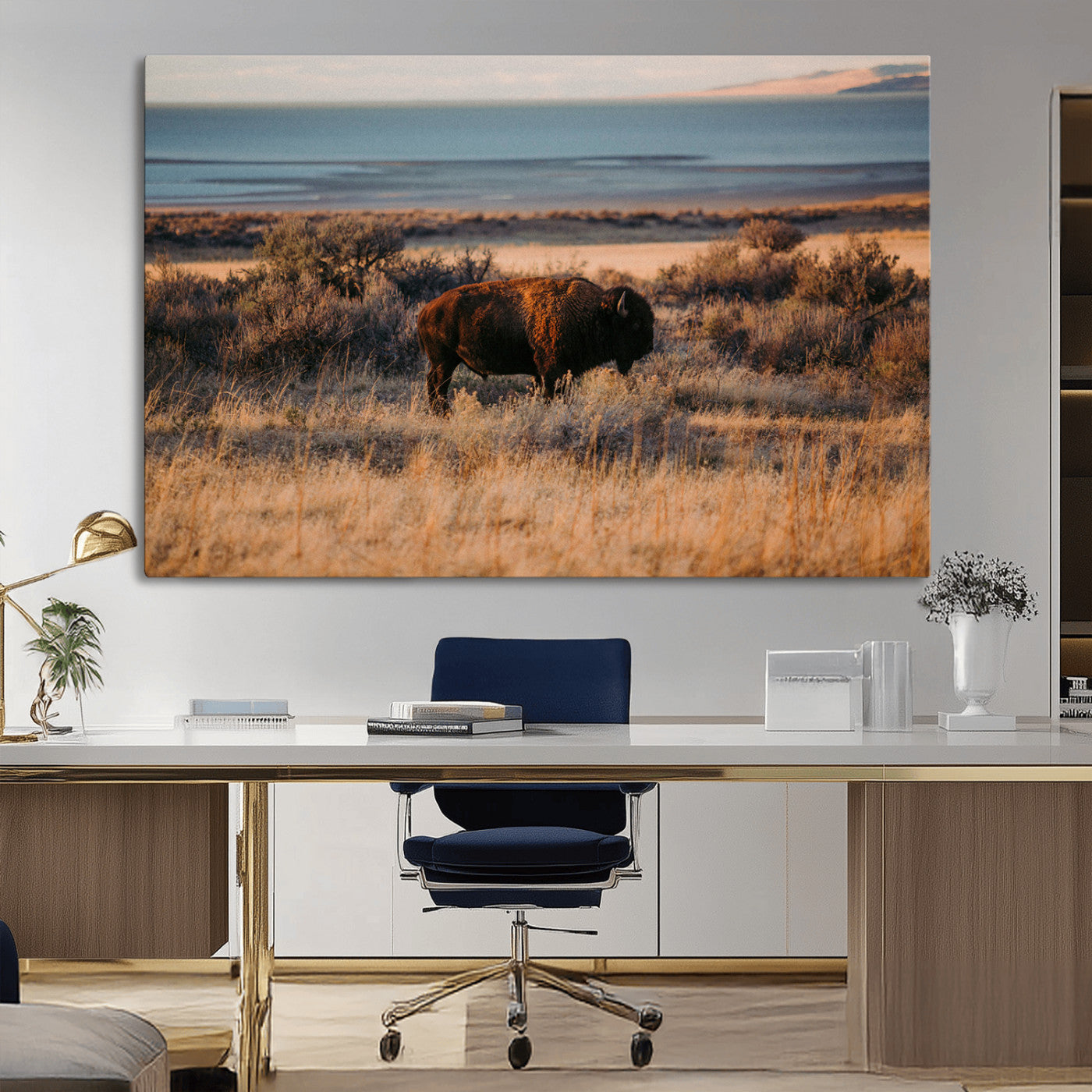 A lone bison grazing in golden prairie grass at sunset, with warm earthy tones and a distant lake view, perfect for rustic and western decor.