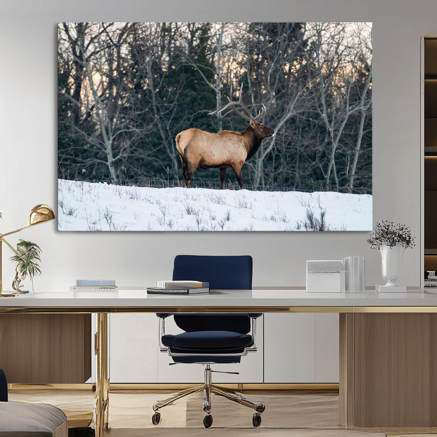 A majestic elk with large antlers standing in a snowy field against a winter forest backdrop, perfect for rustic and wildlife-themed home decor.