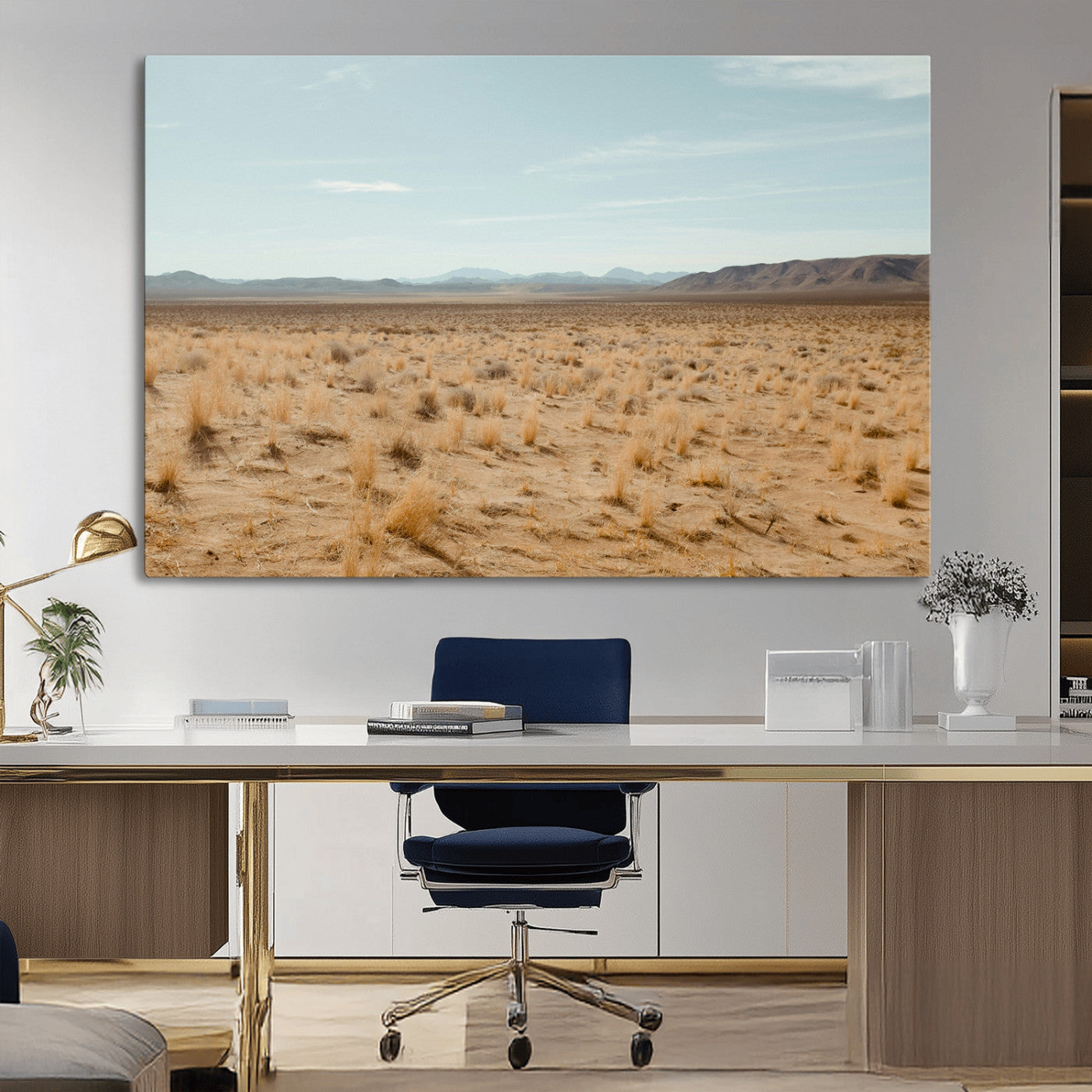 Expansive desert landscape with scattered dry grass and distant mountain range under a pale blue sky – Wall Art Canvas Print.