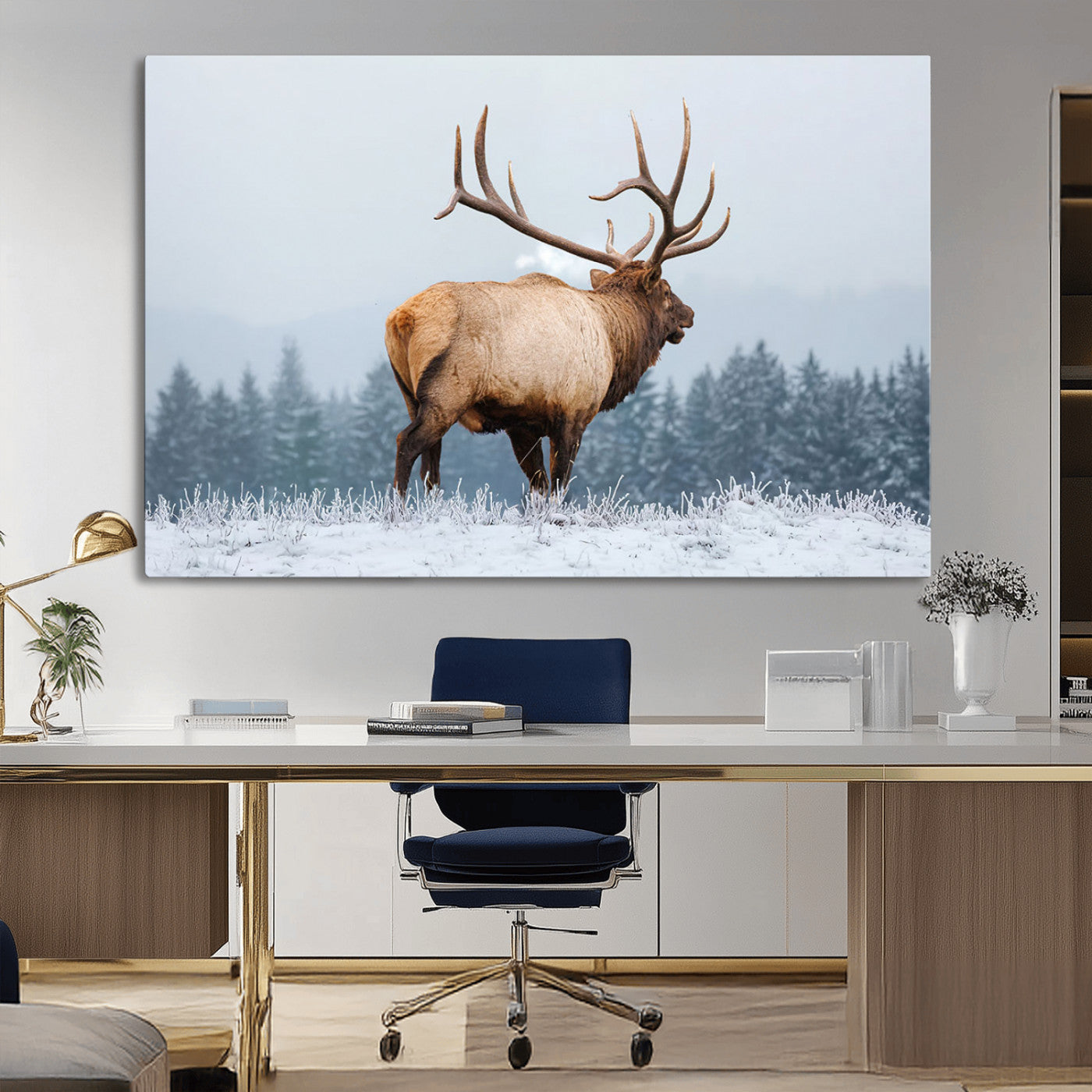 A majestic elk standing in a snowy landscape, with large antlers, set against a backdrop of evergreen trees and a soft winter sky.