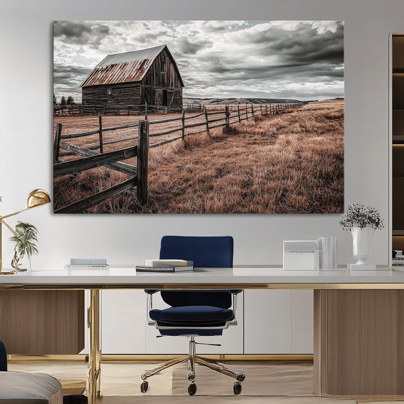 "Black-and-white photograph of a rustic barn with a weathered roof, surrounded by a wooden fence and vast golden fields under a moody sky."