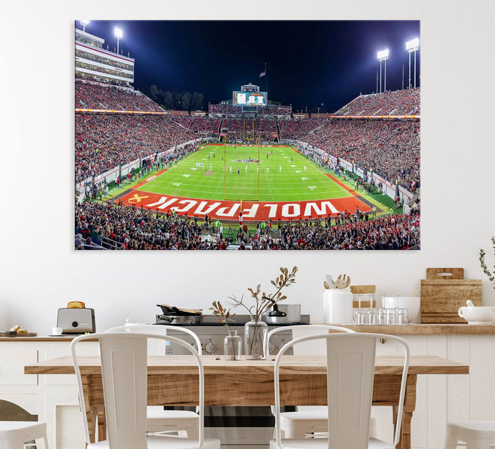 A NC State Wolfpack Football Team print of Carter-Finley Stadium at night features WOLFPACK illuminated brightly in the end zone grass.