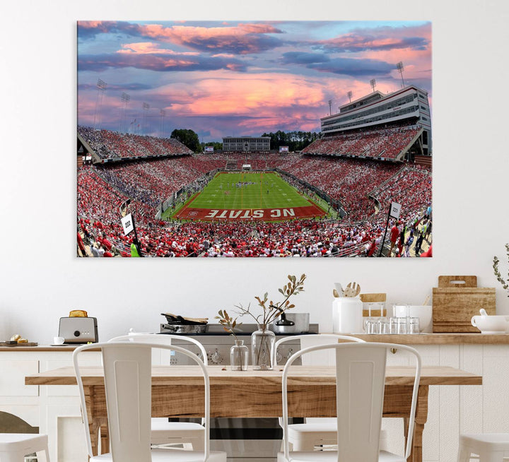 The wall art captures an NC State Wolfpack game under a vibrant sunset on triple canvas.