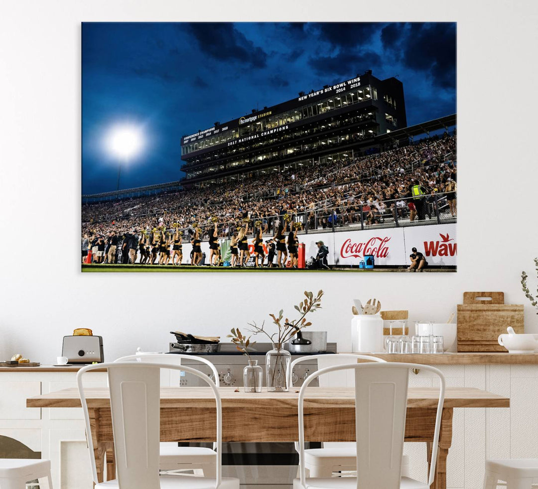 A gallery-quality canvas print depicting a stadium packed with fans under a night sky, highlighting the UCF Knights Football Team.