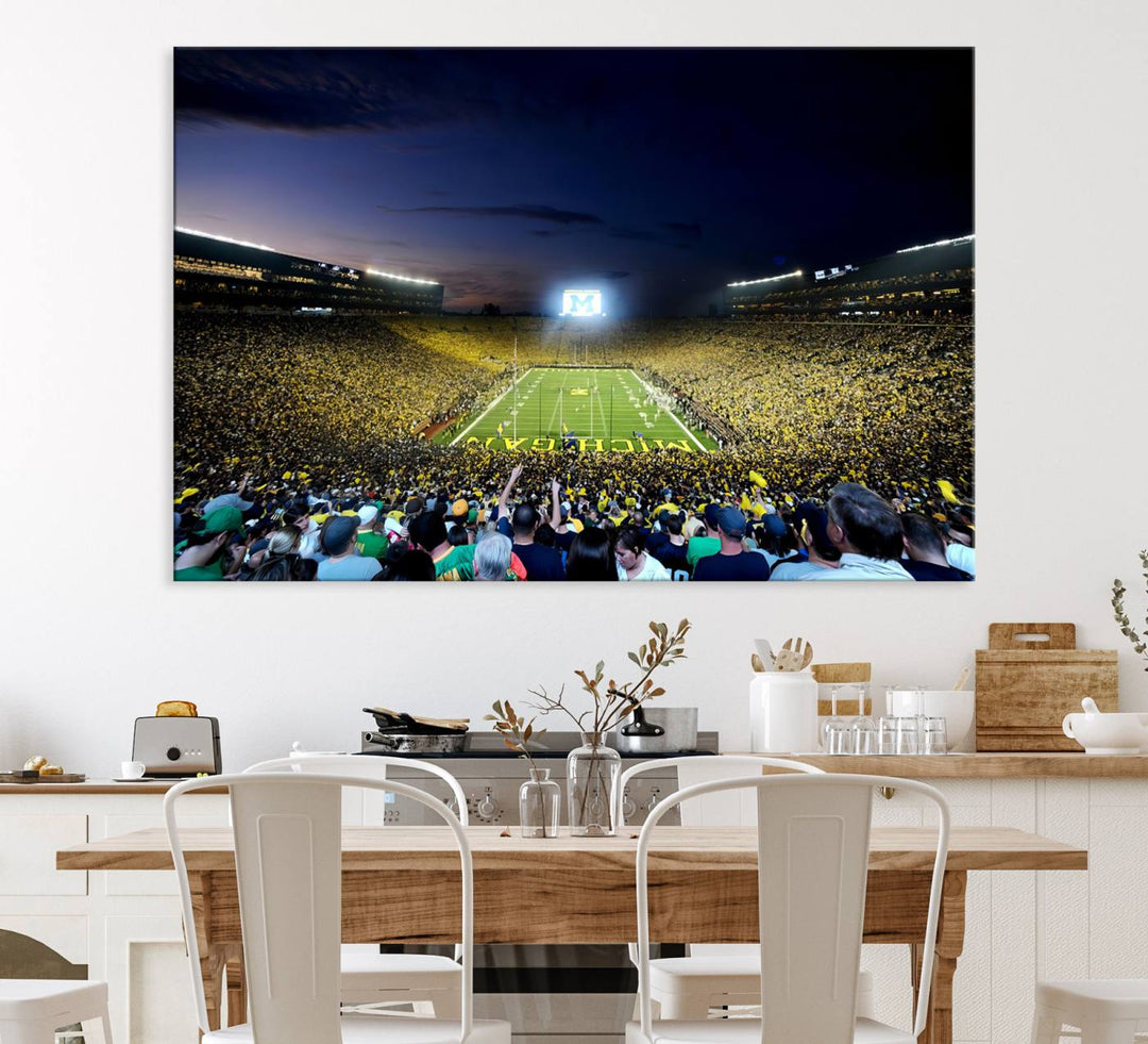 The wall art features a glowing M in this Michigan Wolverines Football Team Ann Arbor Stadium Canvas Print.